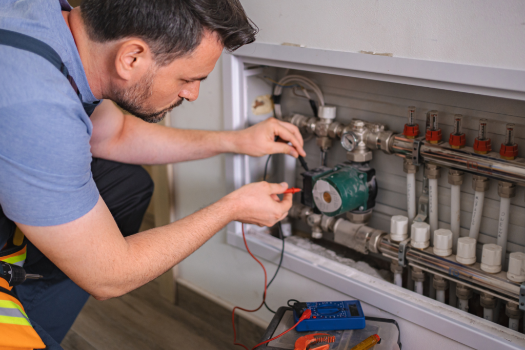 A Man Working On A Machine, Expertly Handling Furnace Services To Ensure Optimal Performance.